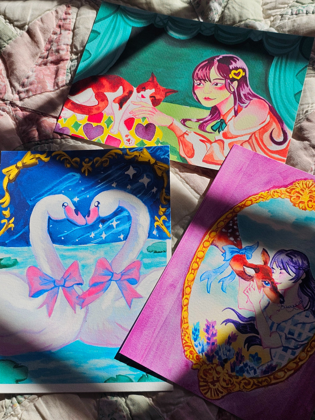 Colorful post cards featuring various characters on a quilted surface.