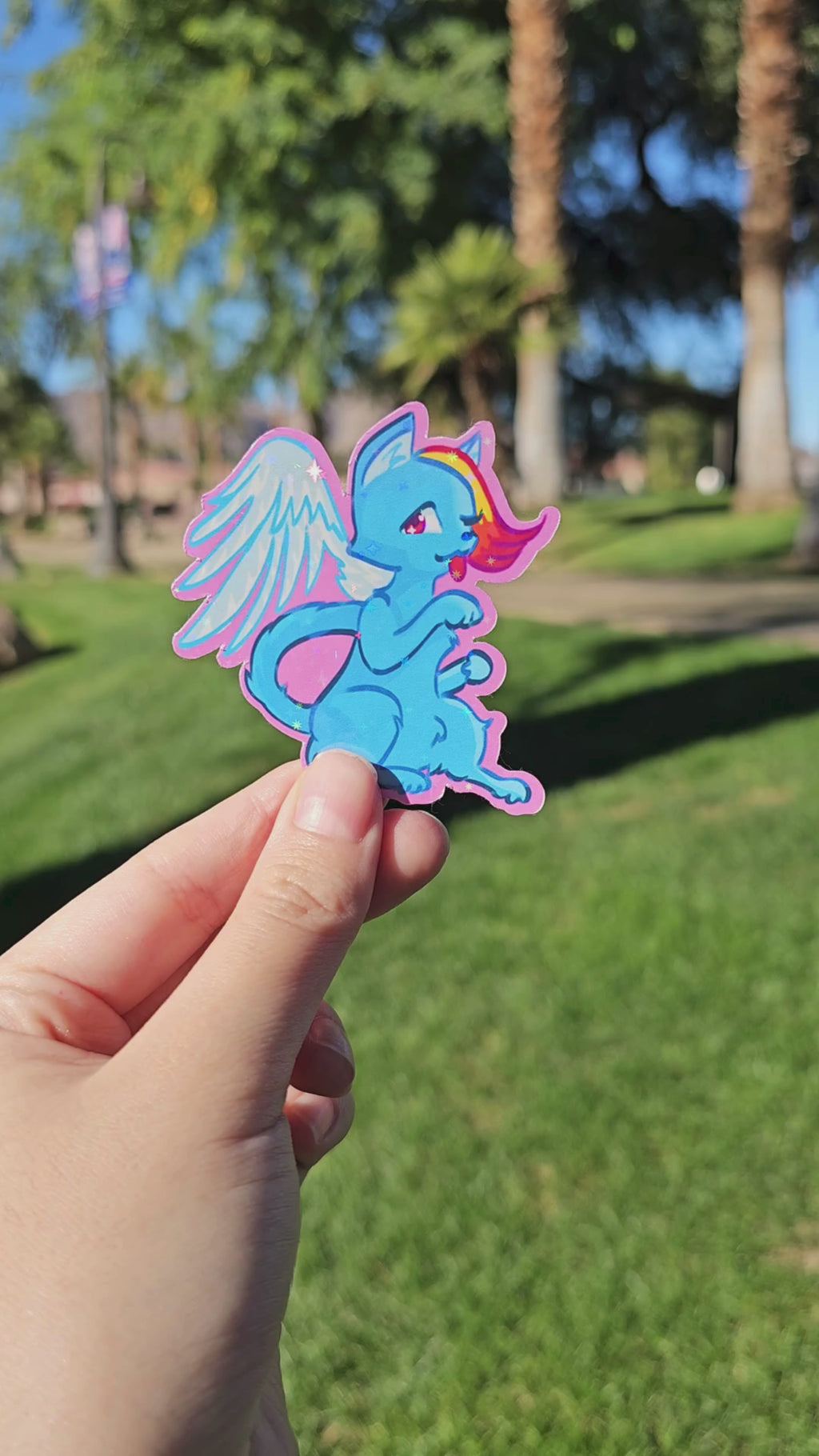 A muted video displaying the holographic finish of the Rainbow Runner Cat die-cut sticker.