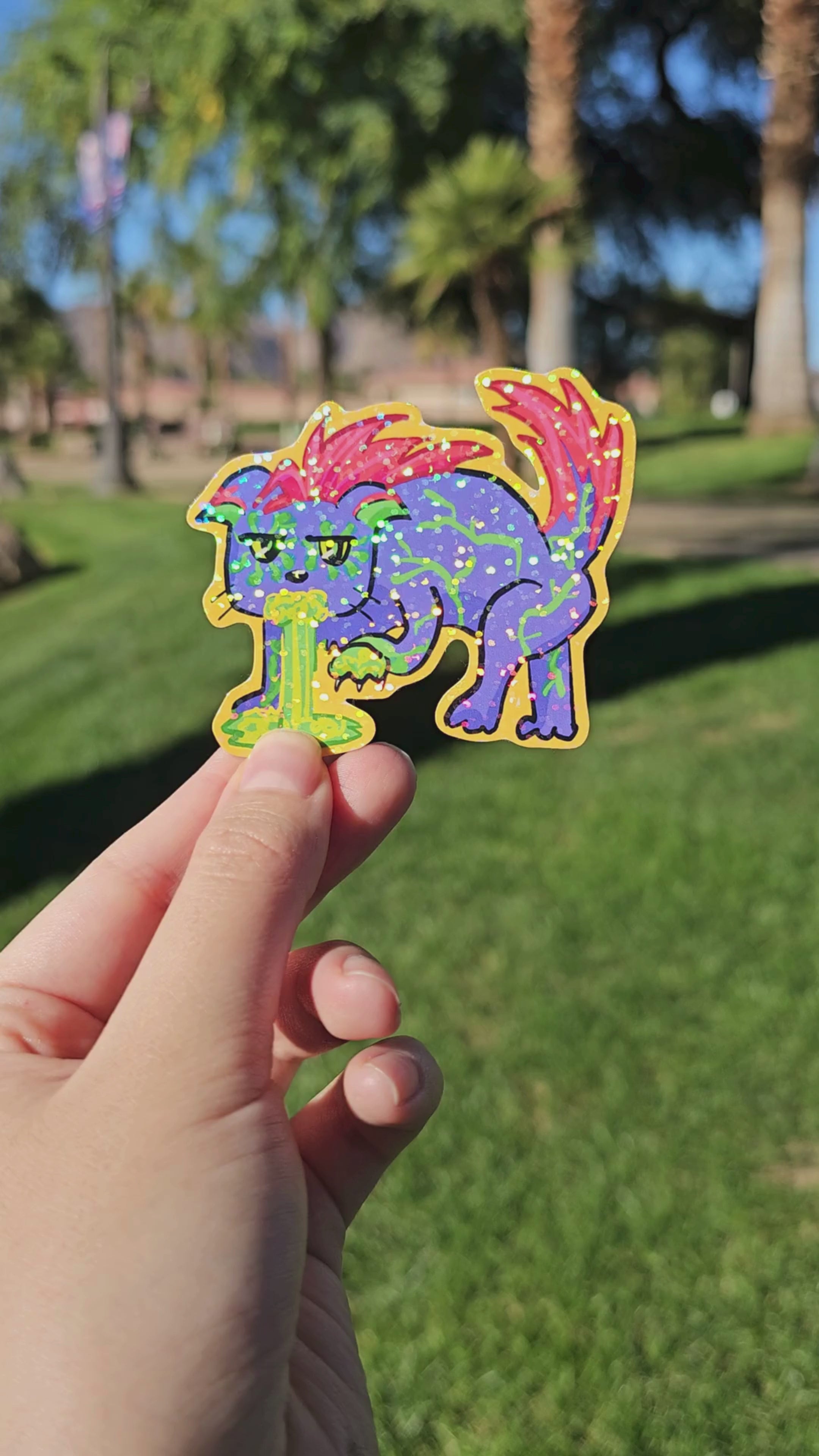 A muted video displaying the holographic finish of the Toxic Waste Cat die-cut sticker.